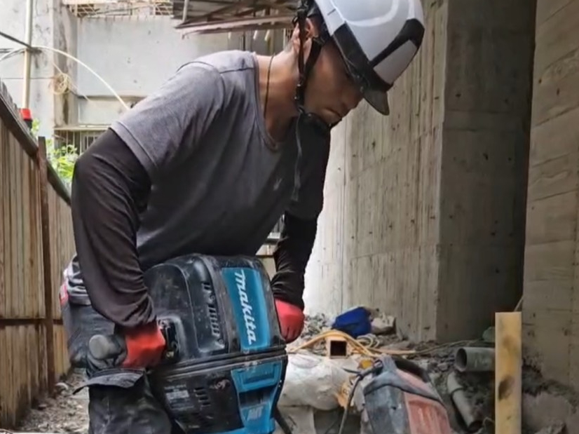 工人穿戴安全裝備,在建築結構中進行打石作業